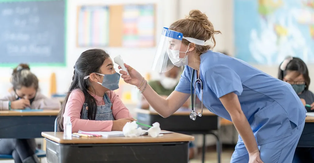 School nurse taking temperature of student