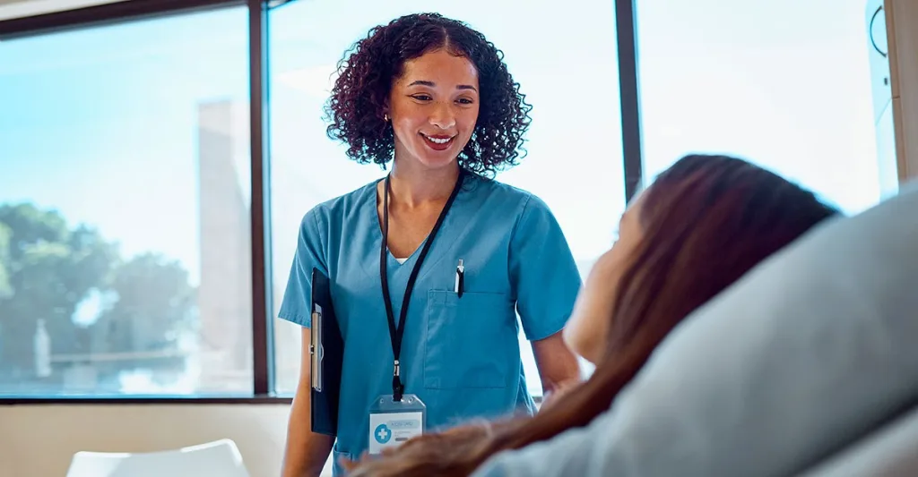 Nurse talking with patient at bedside