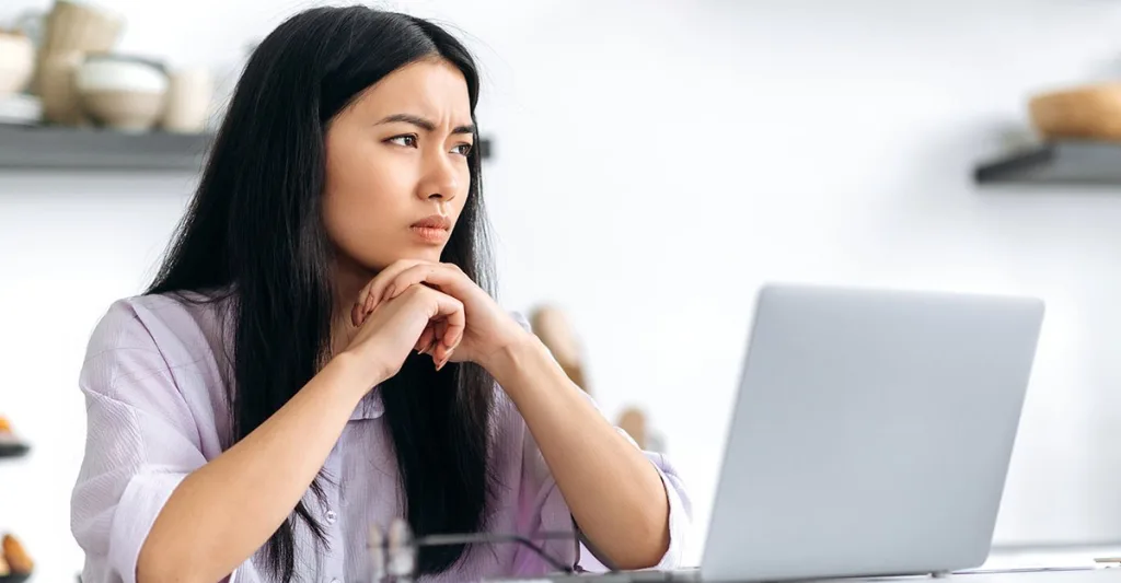 Women sitting at computer doing nursing CE looking off into the distance