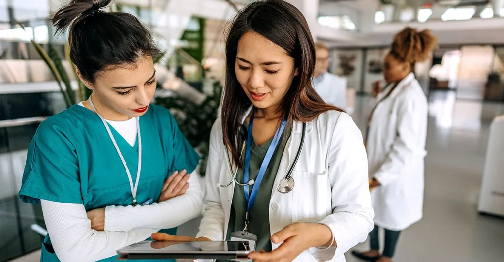 Two nurses reviewing tablet