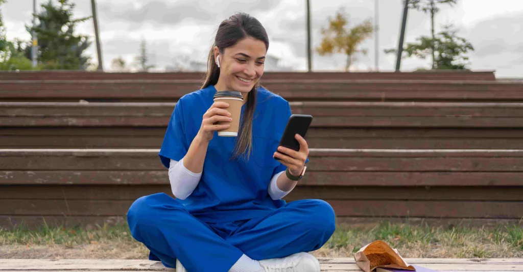 Nurse using social media on phone outside