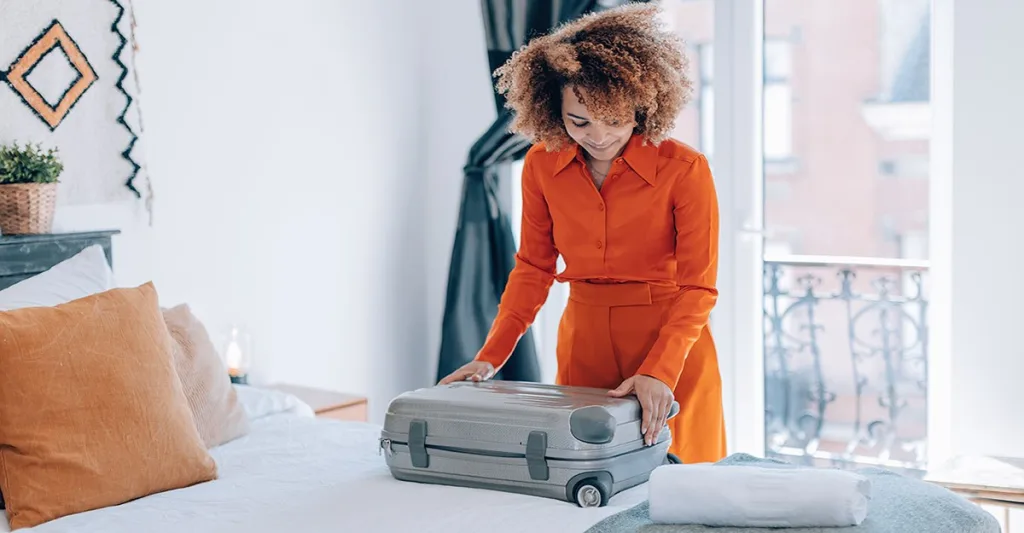 Woman hired by best travel nurse companies unpacks luggage