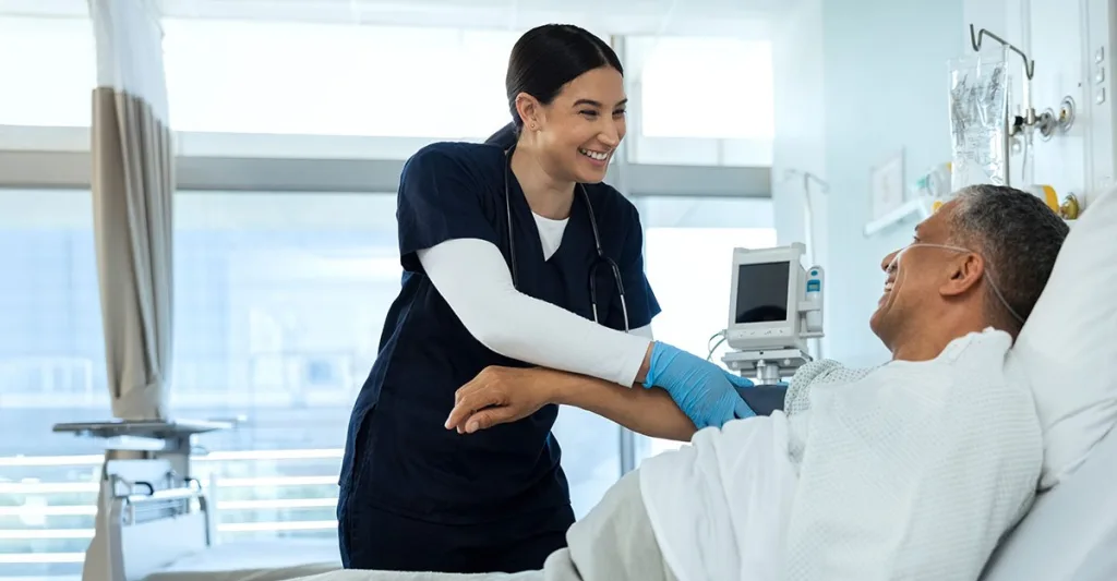 Med surg nurse helping a male patient in a hospital bed