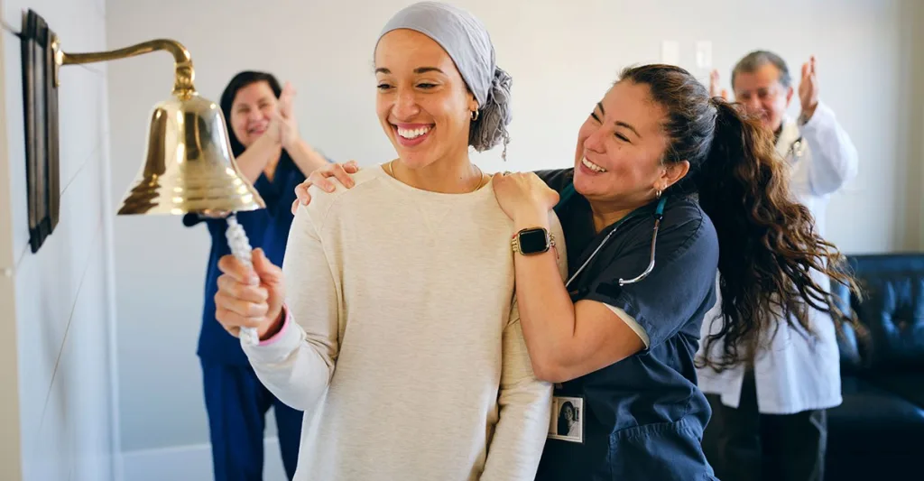 An oncology nurse with a patient who recovered from cancer