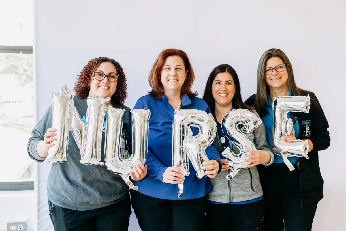 4 nurses holding balloons spelling out nurse