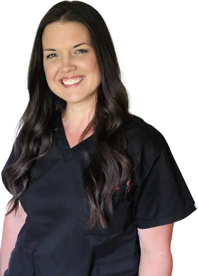 Dark haired nurse in dark scrubs smiling while looking at the camera