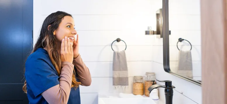 Nurse looking in a mirror, practicing self-compassion