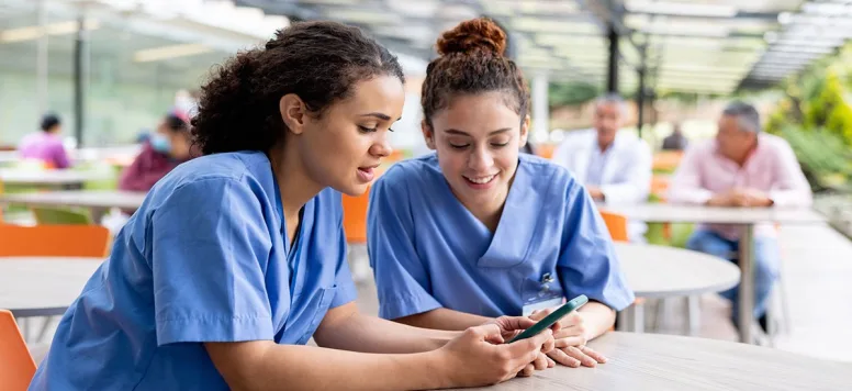 Female nurses sitting at a table focused on nurse wellness