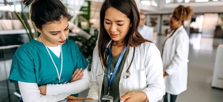 Two nurses reviewing tablet