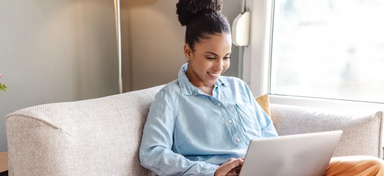 Woman on laptop on her couch