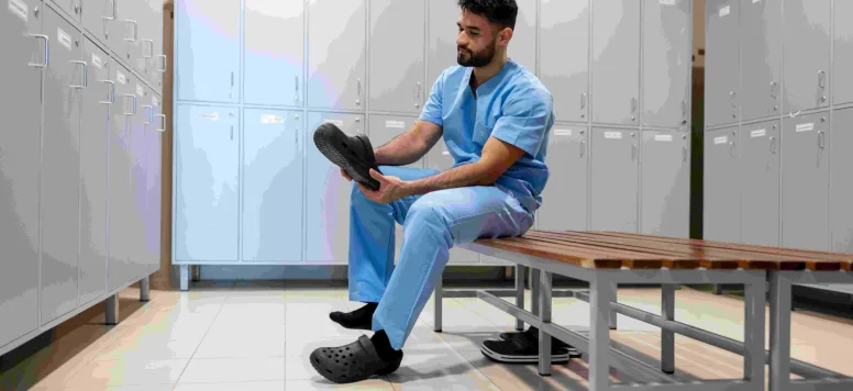 Male nurse putting on his shoes in the locker room