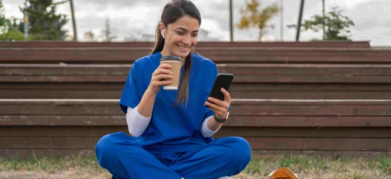 Nurse using social media on phone outside