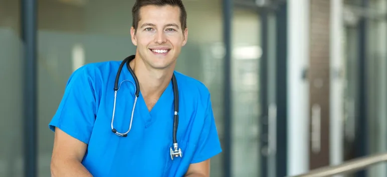 Male nurse wearing scrubs and smiling