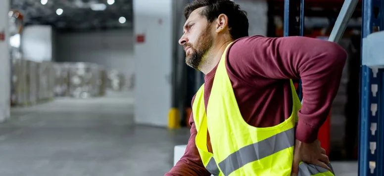 Injured employee holding his hand on his back