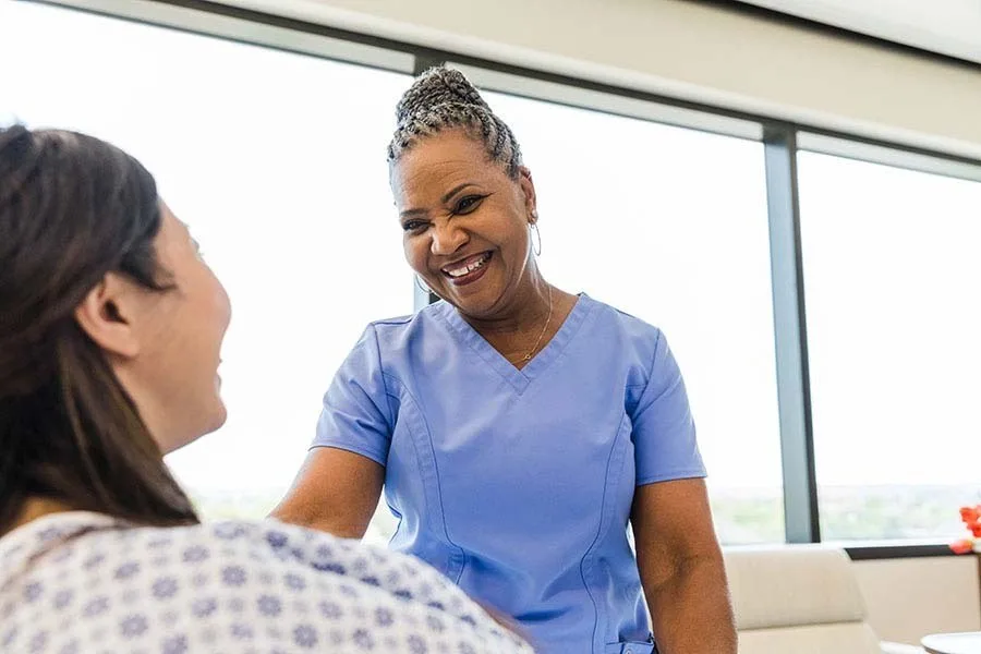 Nurse comforting patient in hospital bed