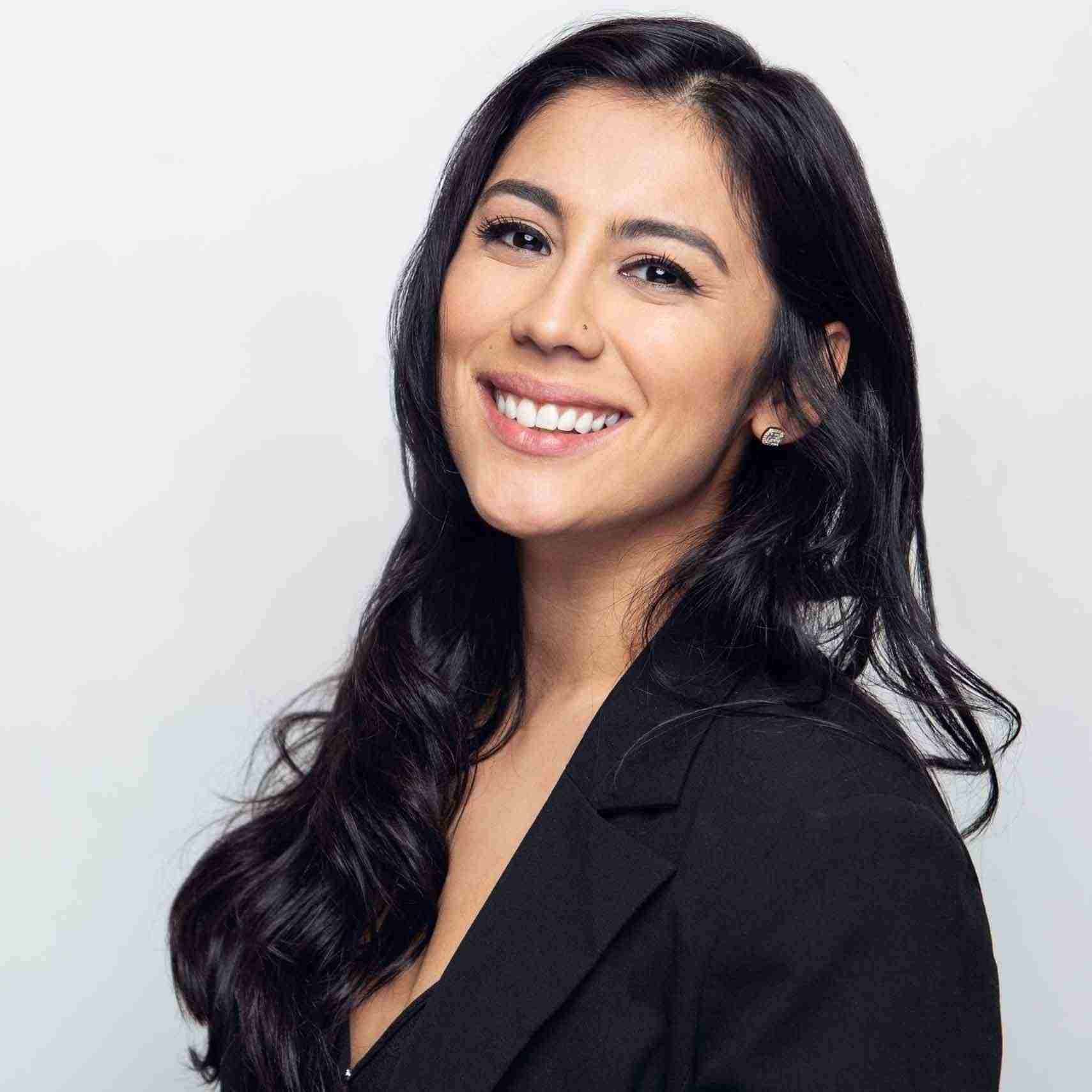 Headshot of smiling woman wearing black blazer discussing preventing workplace injuries