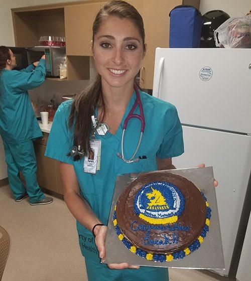 Sarah Sellers, RN, CRNA, with cake celebrating her 2nd place finish at Boston Marathon.