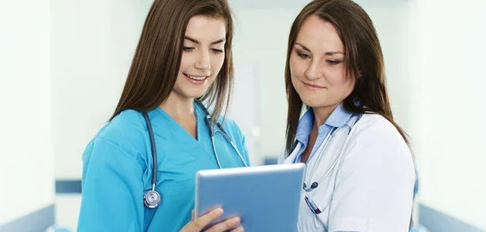 Two nurses reviewing a tablet