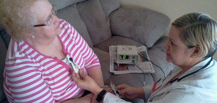 Nurse taking vitals on patient in her home