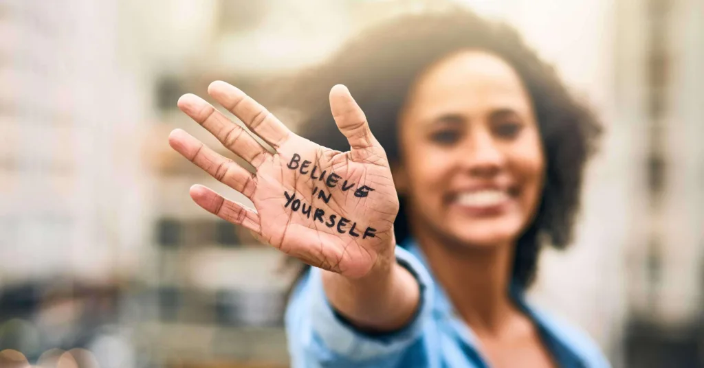 "Believe in yourself" written on a woman's hand