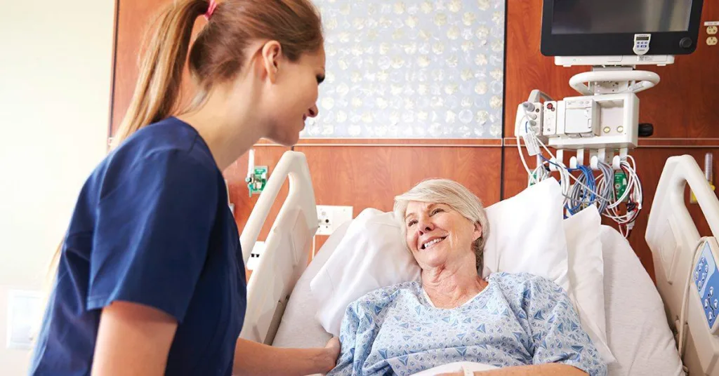 Nurse comforting patient in hospital bed