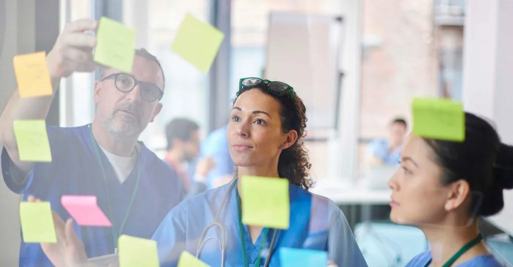 Nurses looking at sticky notes