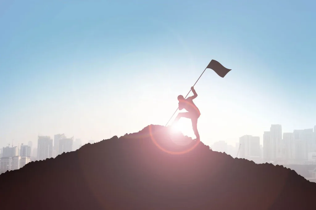 man-planting-flag-on-hill-or-mountain-iStock-626945294.jpg