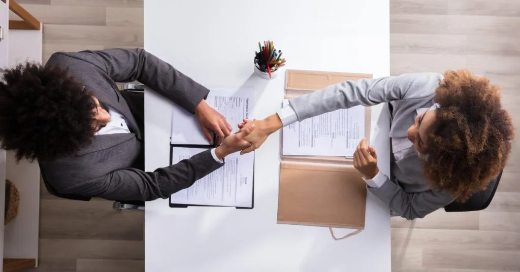 Two people shaking hands after an interview