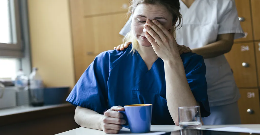 Tired nurse drinking coffee