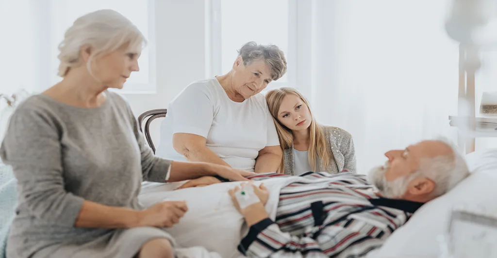 Family-watching-over-patient-in-bed-FB-GettyImages-1199004180.jpg