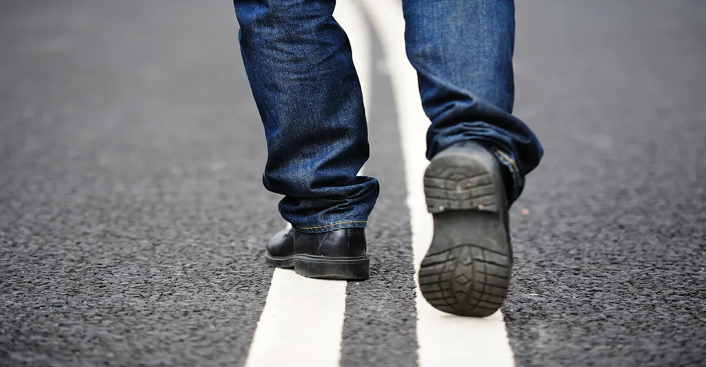 Man walking on the center line of the road