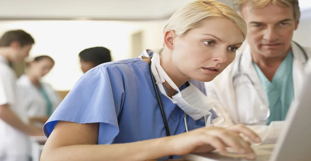 Stressed nurse working on a laptop