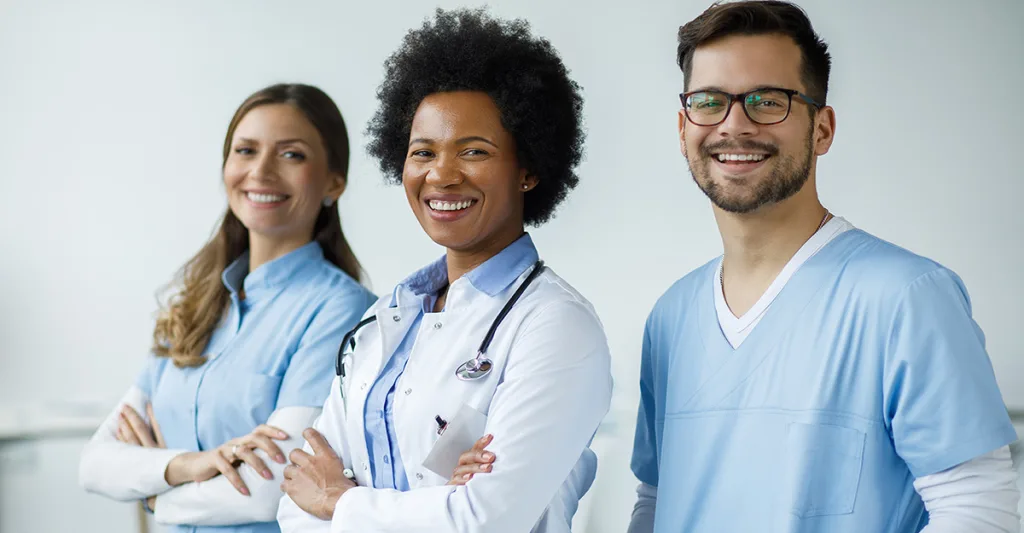 Two female nurses and one male nurse looking at the camera