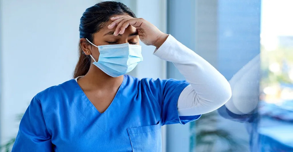 Stressed nurse wearing a mask