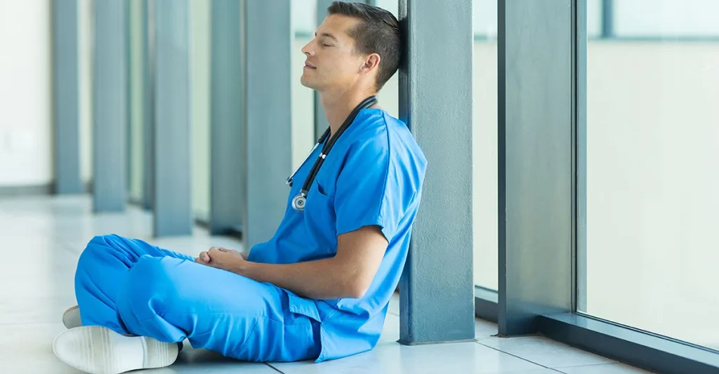 Male nurse resting in hallway