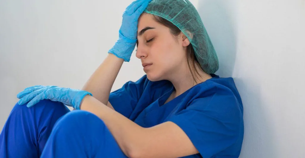 Nurse with her head in her hands