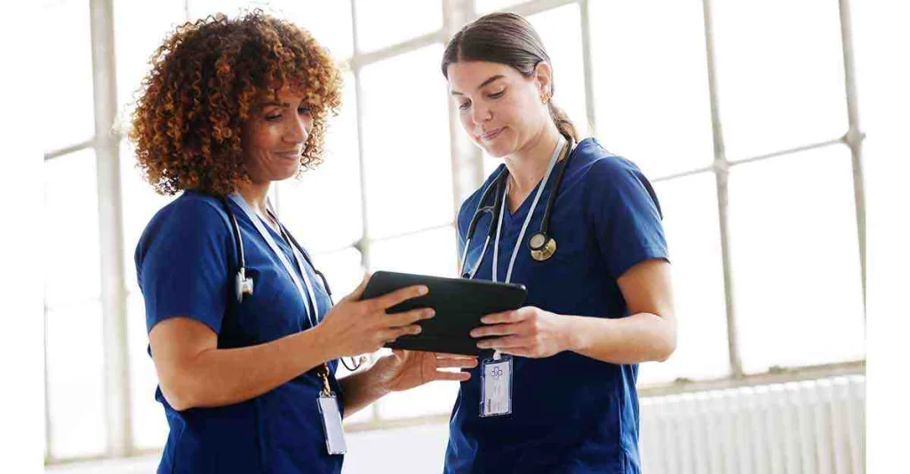 2 nurses looking at a tablet