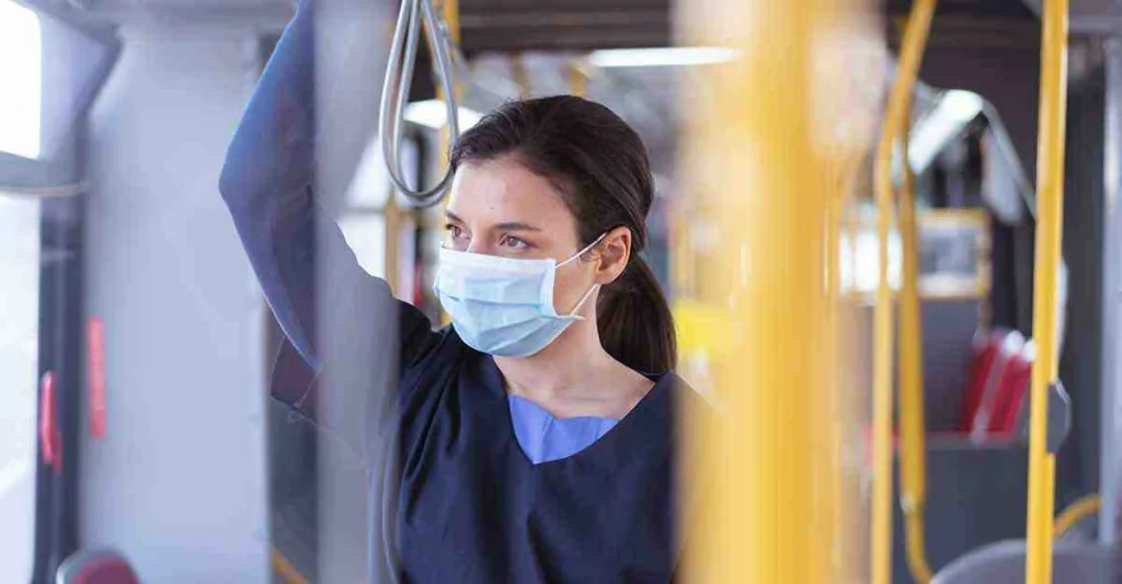 Woman wearing surgical mask traveling on bus