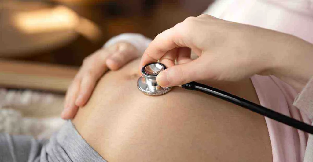 hand-holding-stethoscope-on-pregnant-female-stomach.jpg