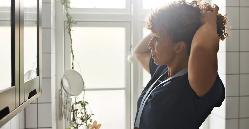 Nurse looking in mirror