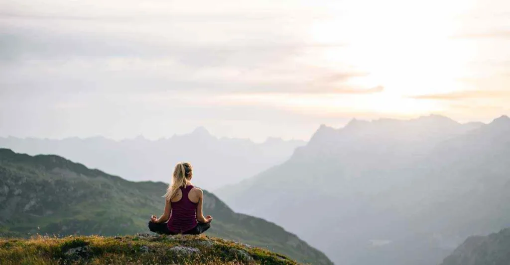 Woman sitting on mountain top