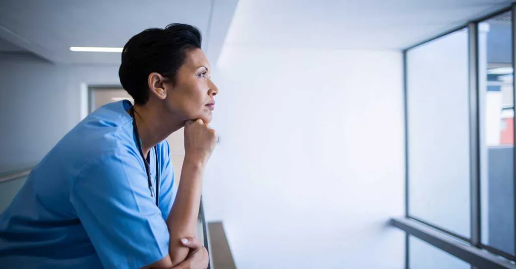 Female nurse looking out window