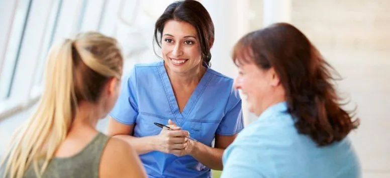 A nurse talking with patient in hallway