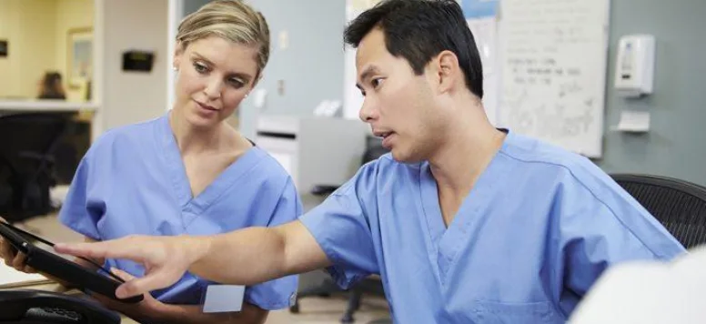 Two nurses reviewing tablet