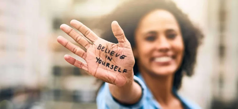 "Believe in yourself" written on a woman's hand