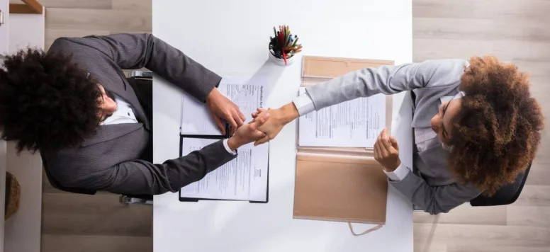 Two people shaking hands after an interview