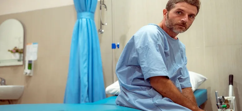 Man-in-patient-gown-GettyImages-1227555146-web.jpg