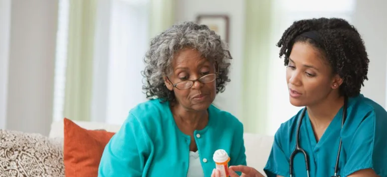 Home health nurse assisting patient