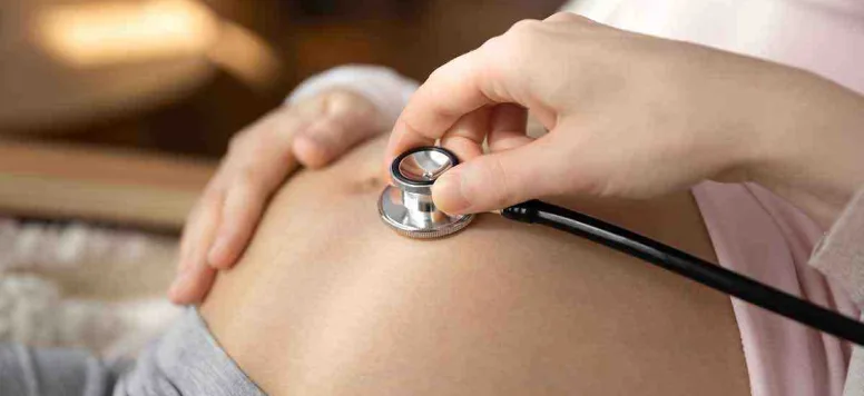 hand-holding-stethoscope-on-pregnant-female-stomach.jpg