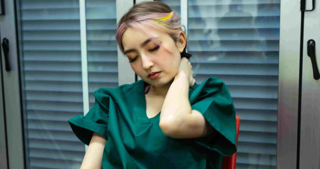 Night shift nurse rubbing her neck.